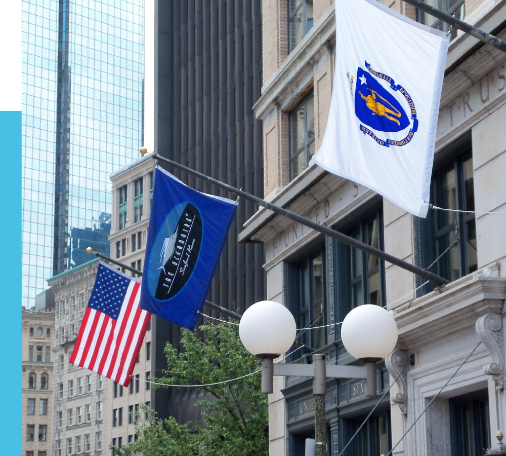 Angled outrigger flagpoles mounted to the side of a downtown building