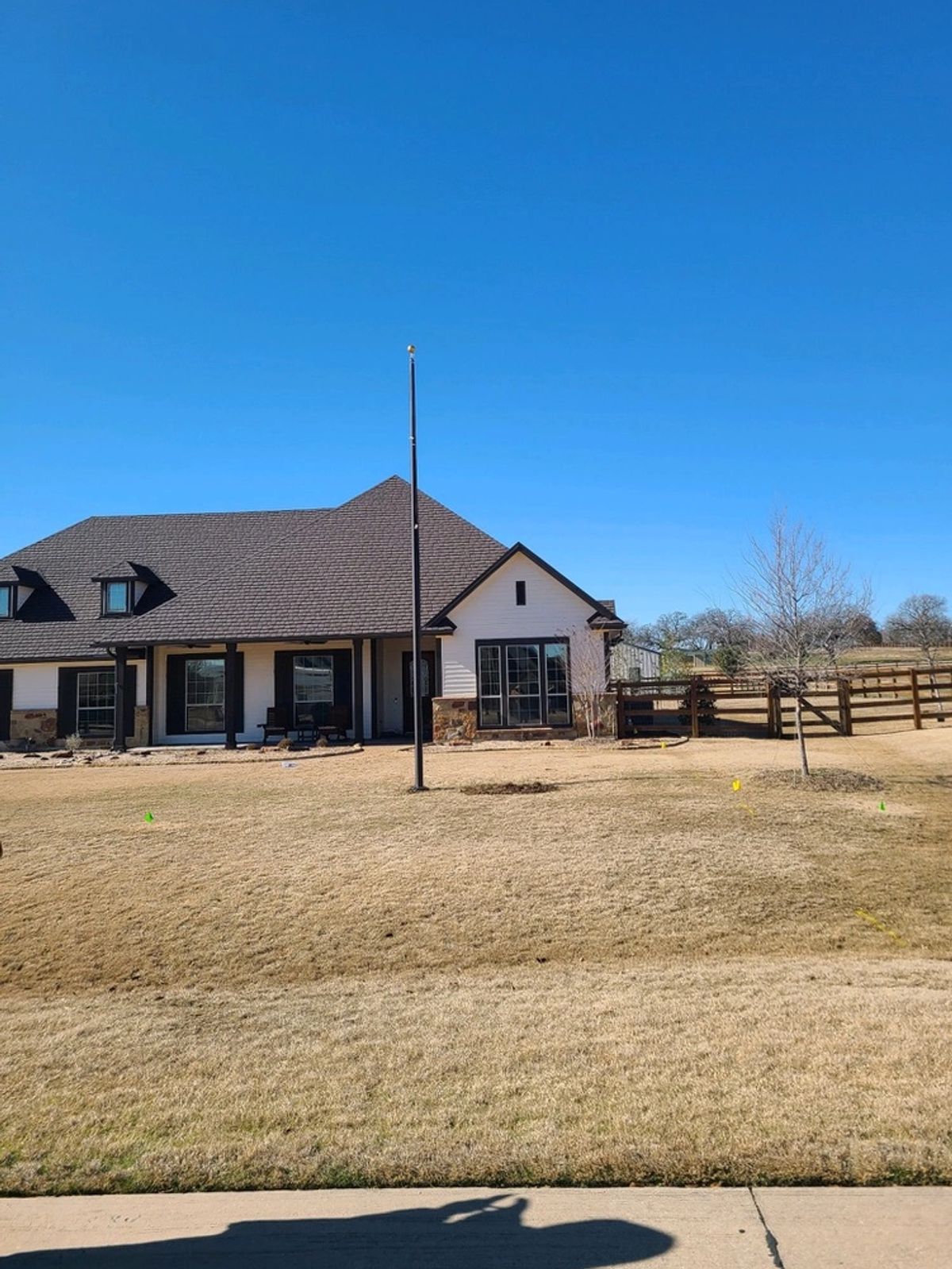 Residential property with a flagpole installed near the home